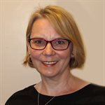 Head and shoulders photo of Mihaela Keleman. Mihaela has blond hair, she is smiling and she is wearing a black top and glasses.