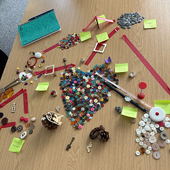 Photo of a table with 'button-maps - made of buttons and tape to illustrate ideas and aspirations for the SNO centre.