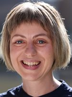 Head and shoulders photo of Lara Bianchi. Lara has jaw length blond bob hairstyle. She  is smiling and is wearing a dark navy top.