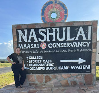 Professor Marina Novelli stood next to the Nashulai Massai Conservancy sign in Kenya