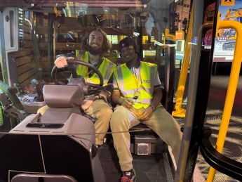 Dan Gill and student wearing yellow jacksts sitting in a yellow digger at JCB_345px