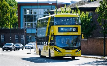 A yellow bus travelling along a street in Bulwell, Nottinghamshire