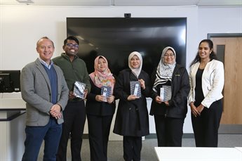 Members of a presentation group receive awards for best presentation.