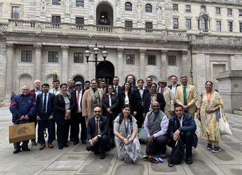 Programme participants and delivery staff stand in a group in front of the Bank of England