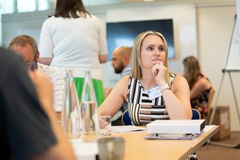 Sarah Armson listening to a speaker at an in-person session for the Help to Grow: Management course