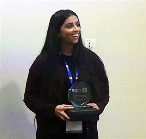 Photo of Anika Dhuna holding her Exceptional Professional Development Award that she received at the 2025 Undergraduate Placement Year Awards.