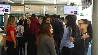 Students networking with industry leaders at the Beyond the Classroom event. Students can be seen talking to each other and industry experts in a meeting room.