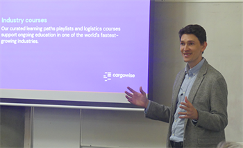 Photo of CargoWise Senior Business Development Executive and Team Lead - Jarred Miltz - stood next to a projector screen giving a presentation.