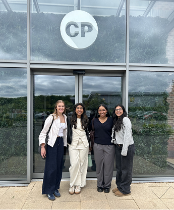 4 Students, including Leah Shah, standing under a Cooper Parry on a visit to their head office