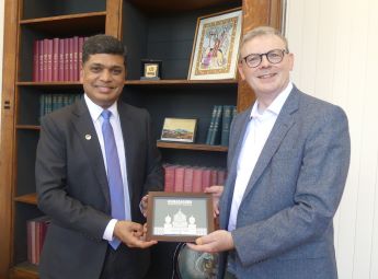 President Shankar Vanavarayar, Kumaraguru Institutions and Professor Nigel Mongan, Associate Pro-Vice Chancellor for Global Engagement, wearing suits and looking at the camera, both holding a gifted picture of  Kumaraguru.