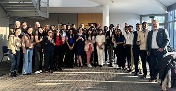 MBA students for the Sustainable Decisions and Organisations module standing in a group in Business School South sunny atrium.