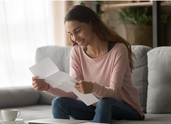 An image of a happy woman reading letter of loan approval