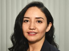 Head and shoulders photo of Gaby Norman. Gaby has long dark hair and is wearing a dark suit jacket.