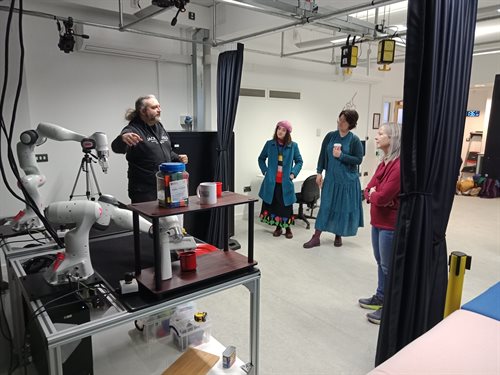 Dominic explains the functionality of the robot to the left of the image