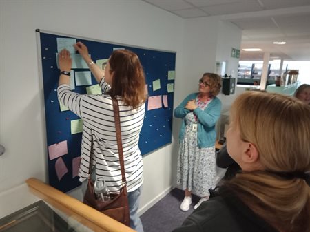 Post-it notes with attendees' responses to the task given being pinned on a board.