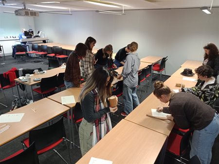 Students and staff collectively working out what the objects laid out were, from which time period they originated, and what they were used for.