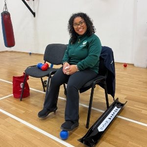 Ellie Stewart sitting in a sports hall