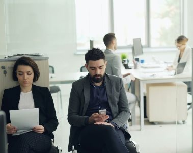 One person being interviewed and two people waiting outside the room for their interview