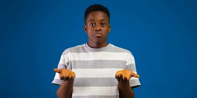 Photo of a boy shrugging with his hands up