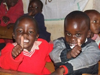 Children giving thumbs up to camera