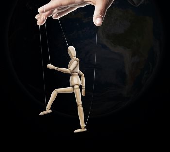 A wooden puppet being moved by a hand