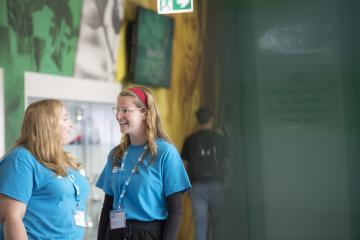 Photo of two students in light blue tops talking