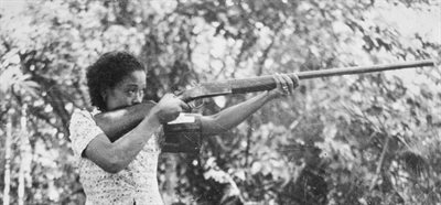Black and white photo of a woman holding a large gun