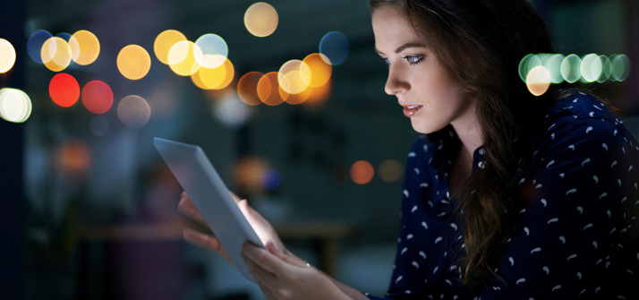 Woman looking at an iPad at night