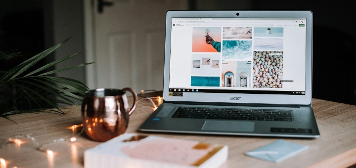Laptop, sitting on a table, open showing a design portfolio on screen