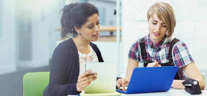 Adviser and student looking at a laptop