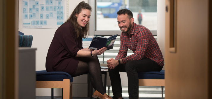 An adviser showing a student a booklet