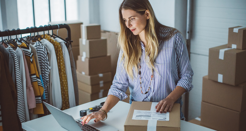 Self employed woman working from home packaging parcels to ship