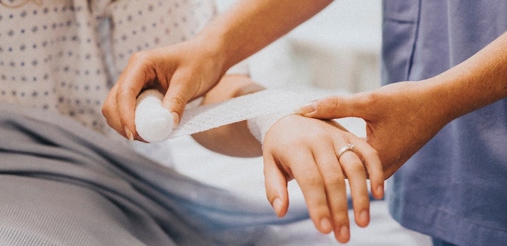 Physicians associate bandaging a patients arm