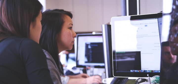 Two people starring at a screen in an office