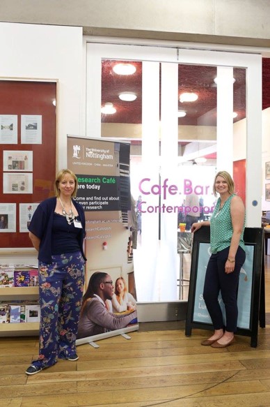 Two smiling researchers standing outside Nottingham Contemporary cafe bar