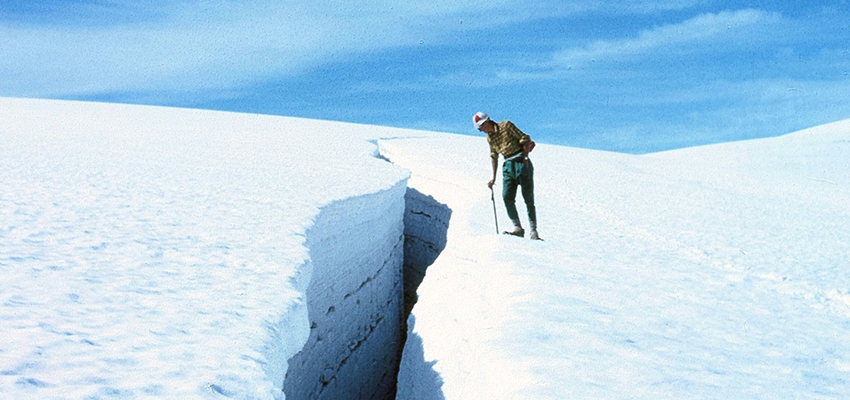 An adventurous student looks into a crevasse in Norway in 1959
