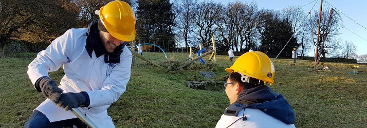 Engineering students installing wind turbine 714x249