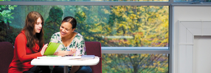 Two female postgraduate students studying in the Graduate Centre, Highfield House, University Park 714x249