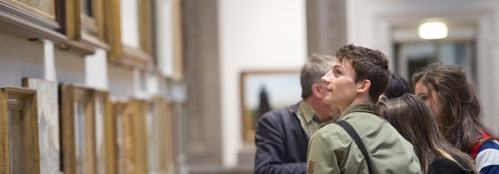 Male undergraduate student looking at a painting, Nottingham Castle - Art History tour 714x249