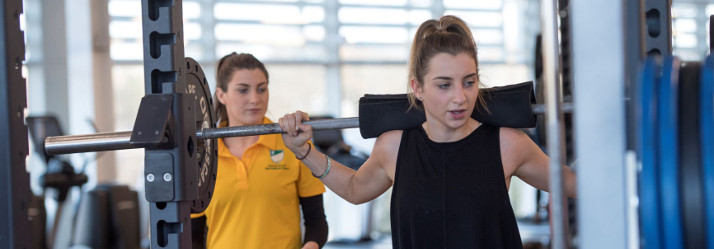 Female student working out at the gym 714x249