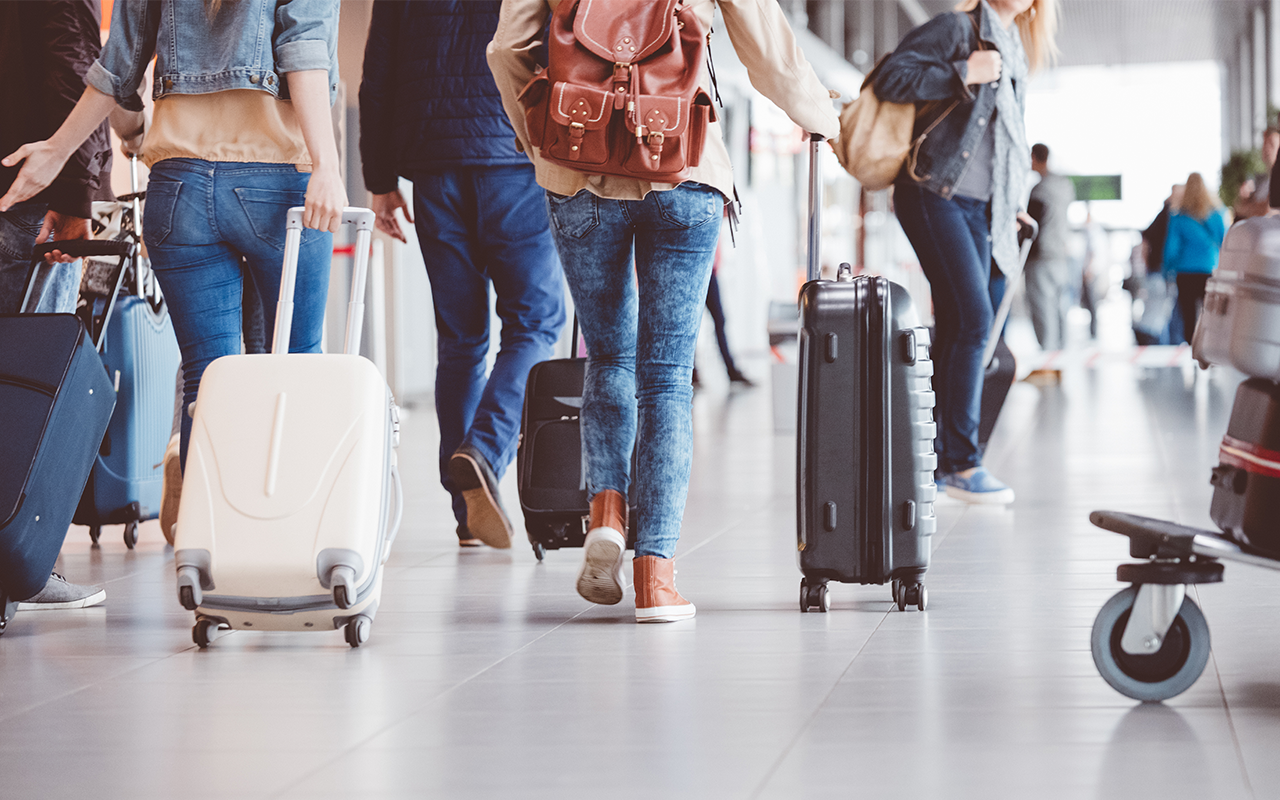 People wheeling suitcases through an airport