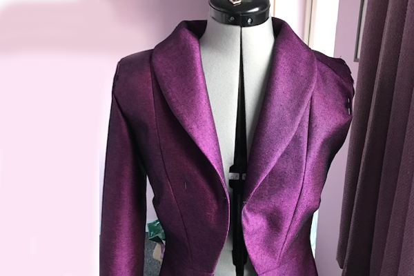 An image of a bright purple fitted jacket on a mannequin designed during lockdown and almost completed (just missing a left arm!)