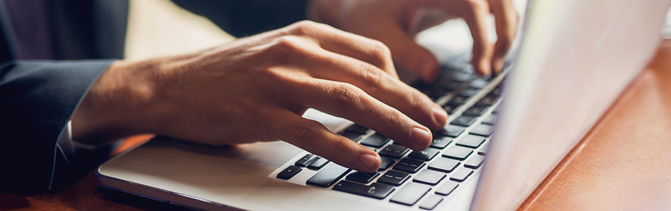 laptop keyboard with hands typing