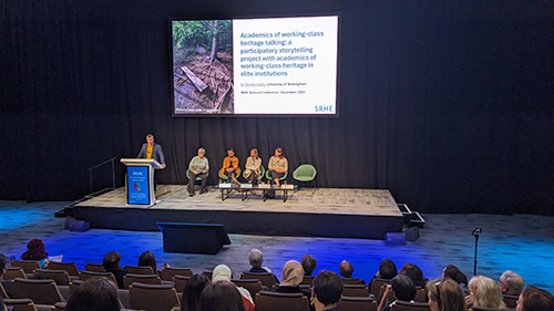 Charlie Davies delivering his presentation with other award winners on stage