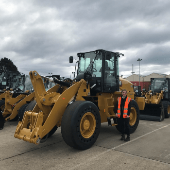 Hannah Rosenbaum stood next to a digger in a high visibility jacket.