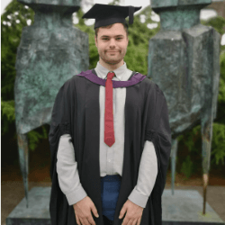 Alex Christie wearing a graduation gown and a mortarboard.