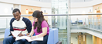 Two students sat in the library working.
