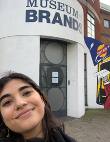 A headshot photo of Tereza Chanki, smiling outside the Museum of Brands