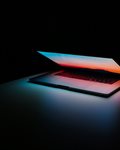 Open laptop on dark background.