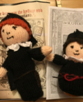 Two knitted dolls on a table.